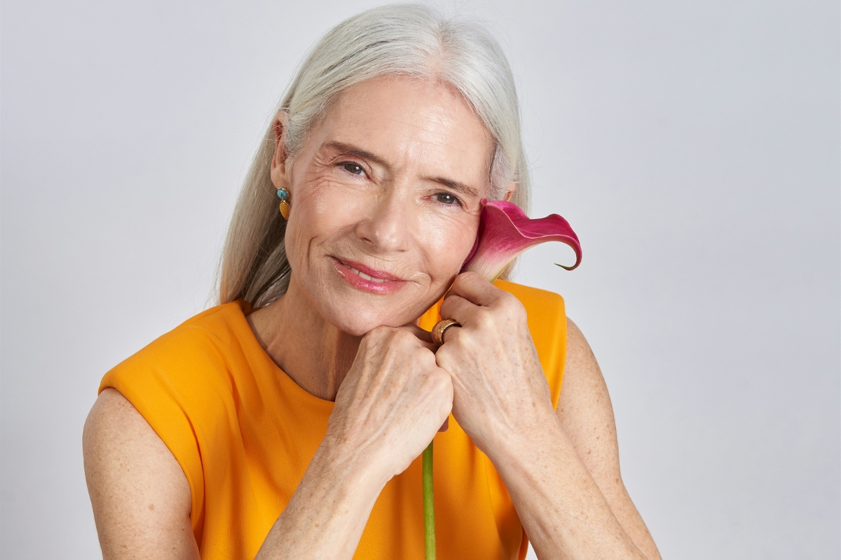 woman holding flower, smiling to evoke happy and calm feeling because she has used herbs for menopause